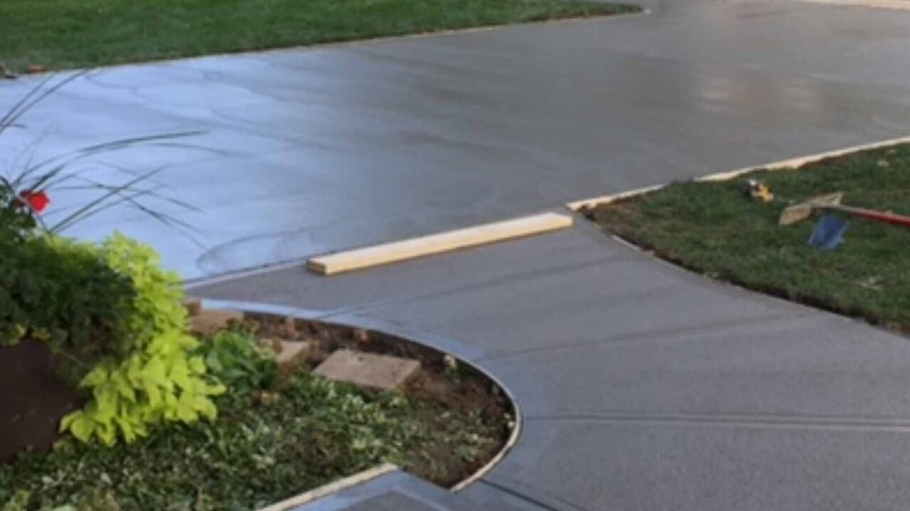 Freshly poured concrete driveway with a curved concrete sidewalk